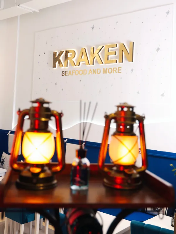 Two brass lanterns under the gold Kraken sign